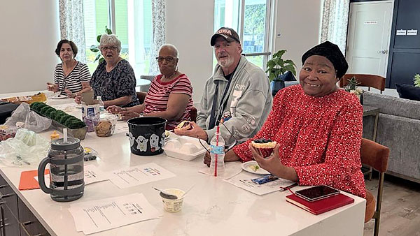 Older adults gathered at a table with food.