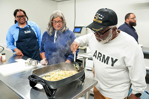 Participant cooks food using an electric skillet.