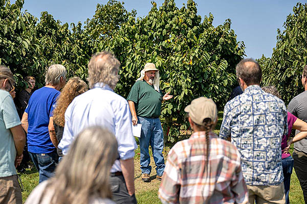 Jeremy Lowe, Kentucky State University horticulture research associate, gives an orchard tour.