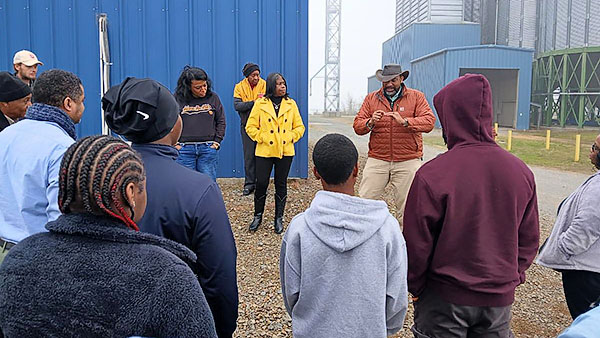 Phillip “PJ” Haynie III tells students about how rice is processed and explains how a grain tank works.