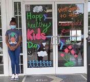 Chesterfield Family YMCA member stands outside decorated door.