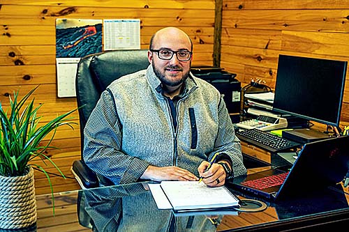 Chris Zeto seated at his desk in Logan County, West Virginia.