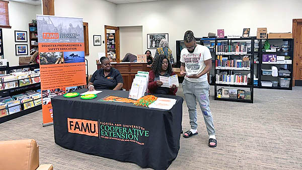 FAMU Extension’s Kimberly Davis and Cheyenne Martin assist a local resident.