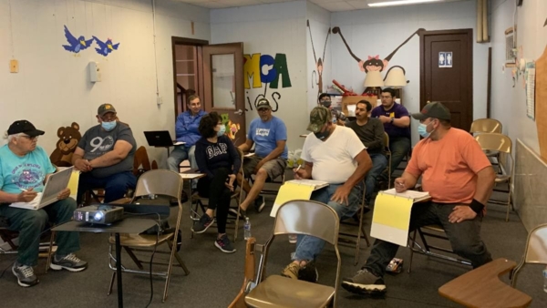 A group of Latino farmers receives training on agribusiness literacy to enhance habits to organize and maintain transaction records on the farm.