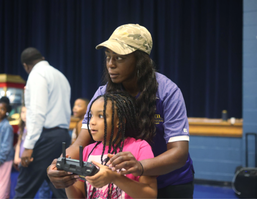 Educator helps youth operate a drone.