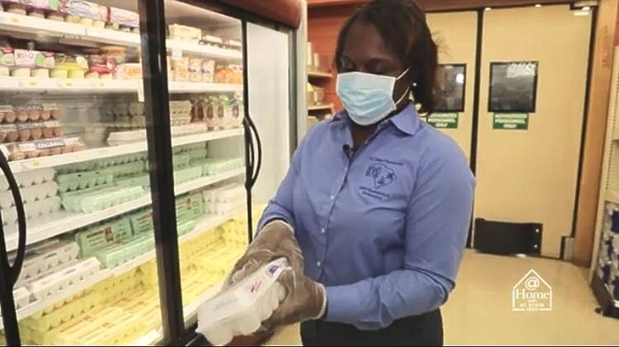 Woman in face mask shopping for eggs in grocery store