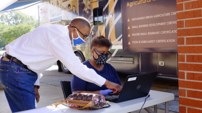 William Augustine assists a client in submitting online documents through the SU Ag Center’s Mobile Technology Education Center on Sept. 4, 2020.