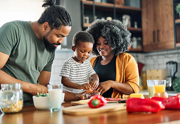A family prepares a meal at the kitchen table.