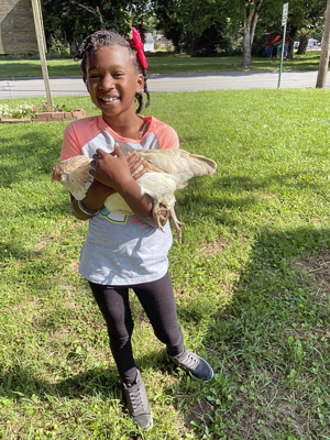 Alyssa Williams holds one of her chickens at the Russellville Urban Garden.