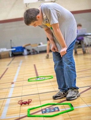 A 4H team member watches as his drone drops right outside the landing zone.
