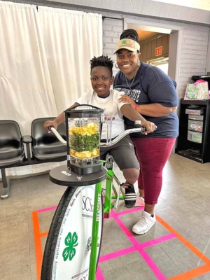 Program participant prepares to pedal on the blend bike to make a delicious and healthy smoothie.