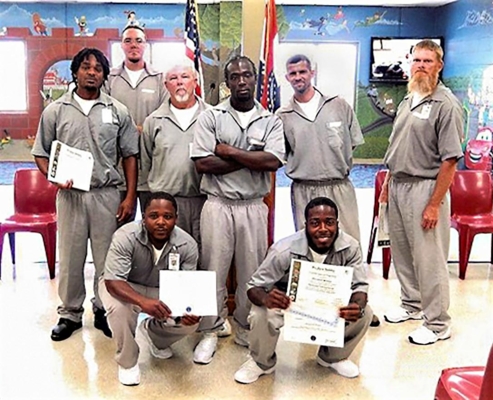 Southeast Correctional Center inmates pose with their certificates at a graduation ceremony following a three-day training program intended to teach them how to do farm work.