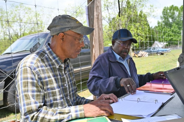 Good Agricultural Practices (GAP) consultant and farmer review paperwork.