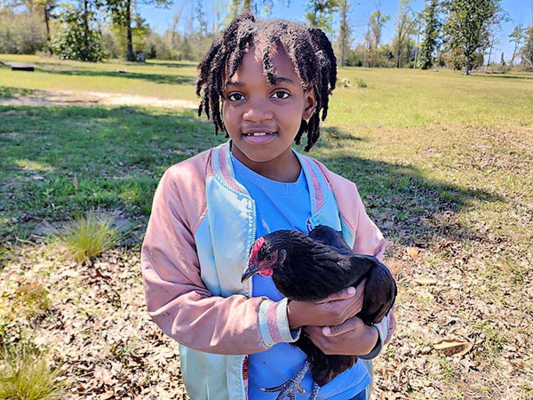 Kodi Hayes holds a chicken.