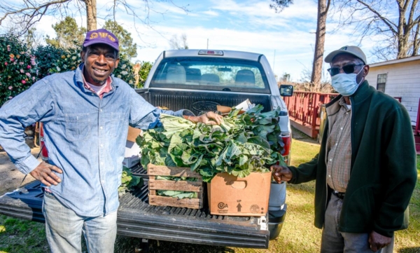 Gregory Odum, a Macon County farmer, and FVSU Macon County Extension agent Ricky Waters, pose with produce grown on the Odum family farm.