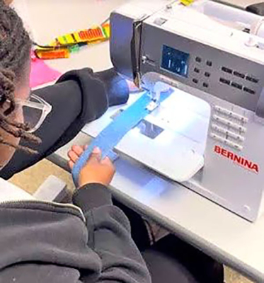 A student learns to sew.