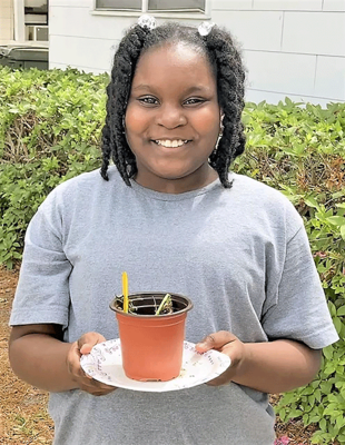 Kiersten Huggins pictured with her homegrown lima bean plant.