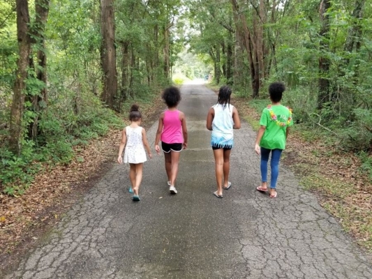 Four youths walking in a wooded area.