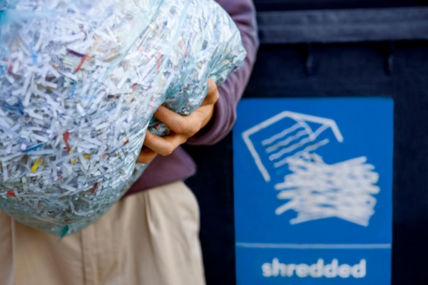 person holding bag of shredded paper