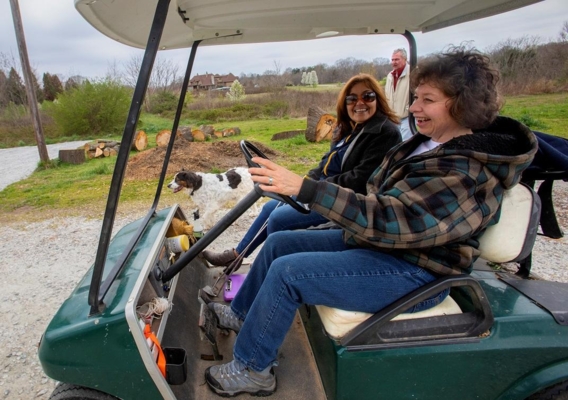 Suzanne Ramsey drives her Gator™ utility vehicle with Beatriz Rodriguez.