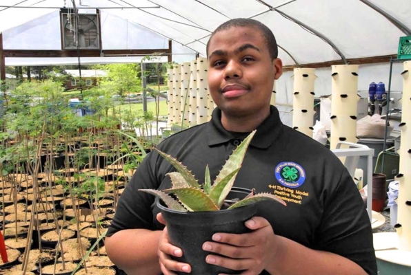 Ty’Jhon Jefferson holds a plant.