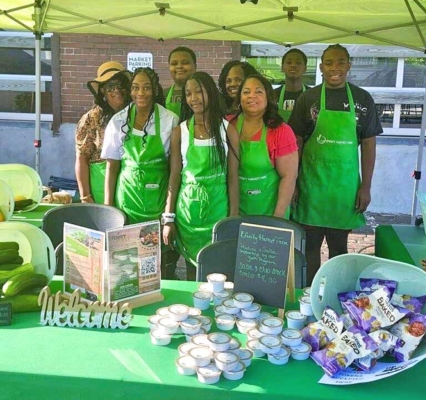 Youth leaders in the Urban Farmer Youth Initiative present their work at a local farmers market.